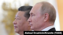 Ресей президенті Владимир Путин (оң жақта) және Қытай басшысы Си Цзиньпин.  