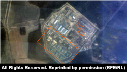 Заходні, самы буйны ўчастак будаўніцтва вайсковага аб’екту на спадарожнікавым здымку 18 сьнежня 2025 году. Абведзеныя склады боепрыпасаў і невялікія ангары з абарончымі землянымі насыпамі.