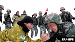 Китайские и таджикские солдаты мерятся силой во время патрулирования рядом с городом Кашгар в автономной области Синьцзян,  Китай. Май 2019 года. 