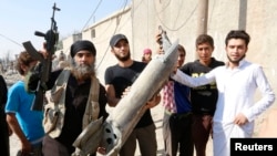 Siriýanyň Rakka şäherinde ýerli ýaşaýjylaryň ýanynda duran "Yslam döwleti" toparynyň söweşijisi (çepde).