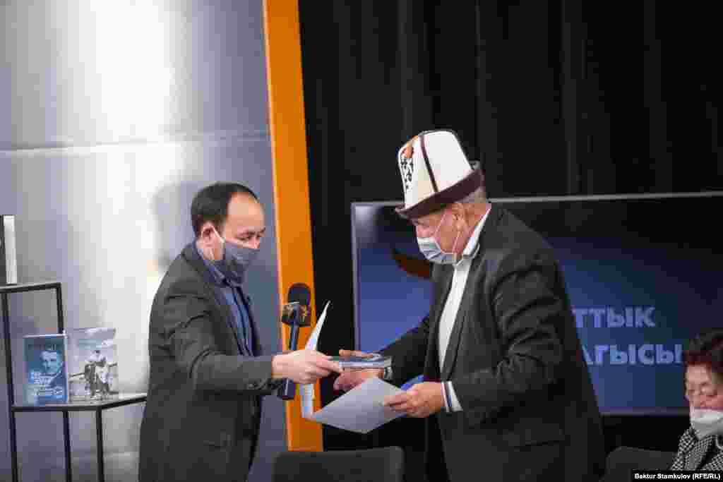 "Азаттыктын" редактору Заирбек Бактыбаев сынакта атайын сыйлыкка татыктуу деп табылган маданий ишмер Келдибек Ниязовго белек&nbsp; берип жаткан учур.