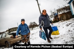 Olekszij Paszjuha, a Vorszkla főszerkesztője az orosz drónok által gyakran támadott északi utcába is kiviszi az újságot egy ott élő előfizetőnek 2025. február 14-én