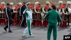 Turkmen President Gurbanguly Berdymukhammedov (center) waves to the media during the starting ceremony of a 500-day nationwide horse race at the historical site of Nisa just outside Ashgabat on May 5, 2016, in preparation for the 2017 Asian Indoor and Martial Arts Games.