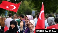 Döwlet agdarylyşygy synanyşygynyň birinji ýyl dönüminde türk baýdagyny göterip, köçä çykan zenanlar. Stambul, 14-nji iýul, 2017.