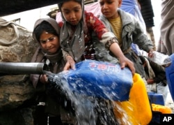 Aglomerație la o țeavă cu apă potabilă gratuită la Kabul, într-o imagine de arhivă, din 2008. De atunci, situația s-a înrăutățit mult.