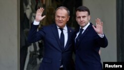 საფრანგეთის პრეზიდენტი ემანუელ მაკრონი (მარჯვნივ) ესალმება პოლონეთის პრემიერ-მინისტრ დონალდ ტუსკს. პარიზი, 17 თებერვალი, 2025.
