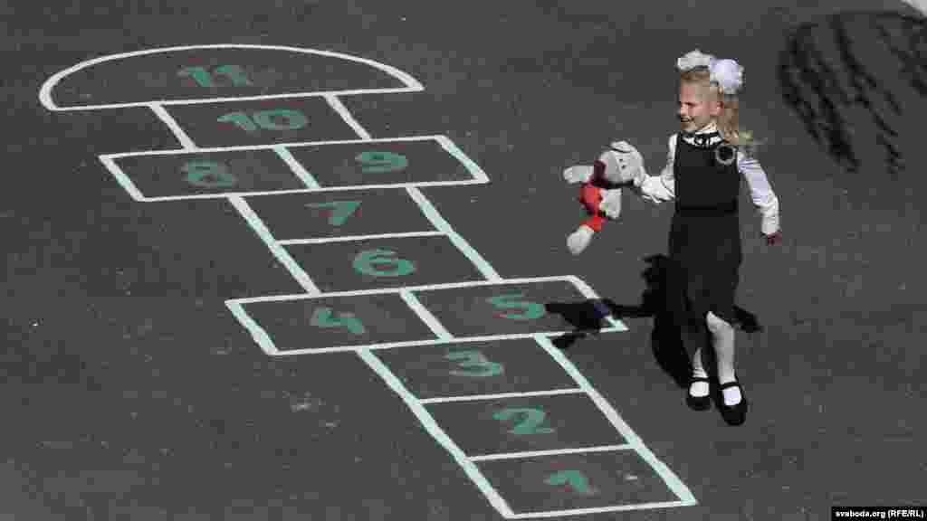 Девочка играет в "классики" во дворе одной из минских школ