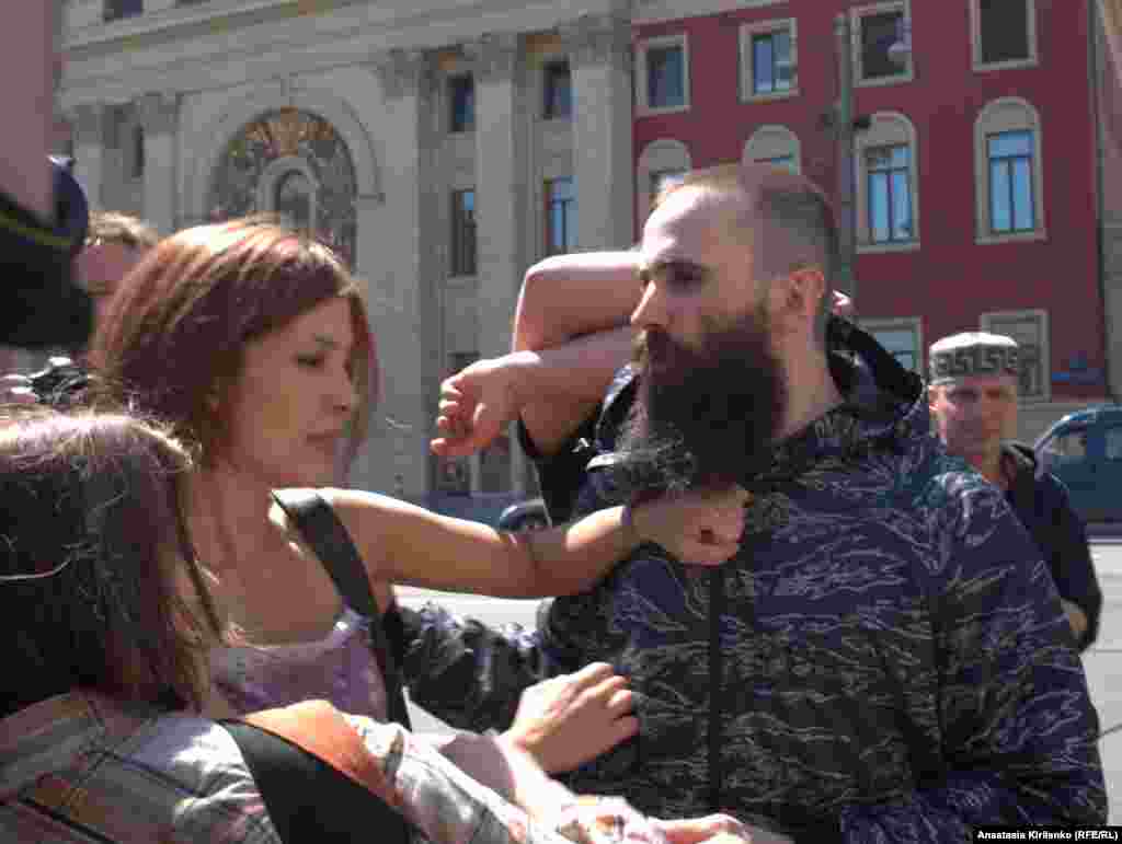 A member of the Russian art collective Voina tries to silence a man yelling, "Moscow without gays!"