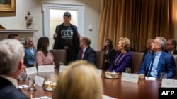 Elon Musk își arată tricoul cu inscripția Tech Support („sprijin tehnic”) la prima ședință a cabinetului lui Donald Trump, pe 26 februarie 2025.