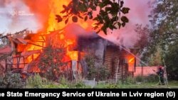 Пожарникар работи на мястото на жилищен район, ударен по време на руски удари с дронове и ракети, в област Лвов, Украйна, 21 август 2025 г.