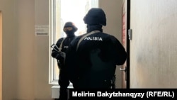 Orda.kz редакциясы есігінің сыртында тұрған қарулы полиция. Алматы, 1 желтоқсан, 2025 жыл.
