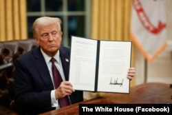 Дональд Трамп показує підписаний ним указ у перші години перебування на посаді президента США