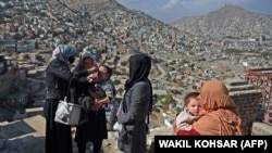 په کابل کې یوه روغتیايي کارکوونکې ماشوم ته د څاڅکو ورکولو پر مهال - د ۲۰۲۱ز کال د نومبر اتمې انځور. 