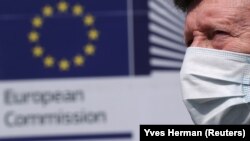 Muškarac sa maskom prolazi ispred sedišta Evropske komisije 