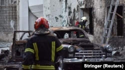 Firefighters work at the site of buildings damaged during Russian drone and missile strikes in Lviv, July 12, 2025.
