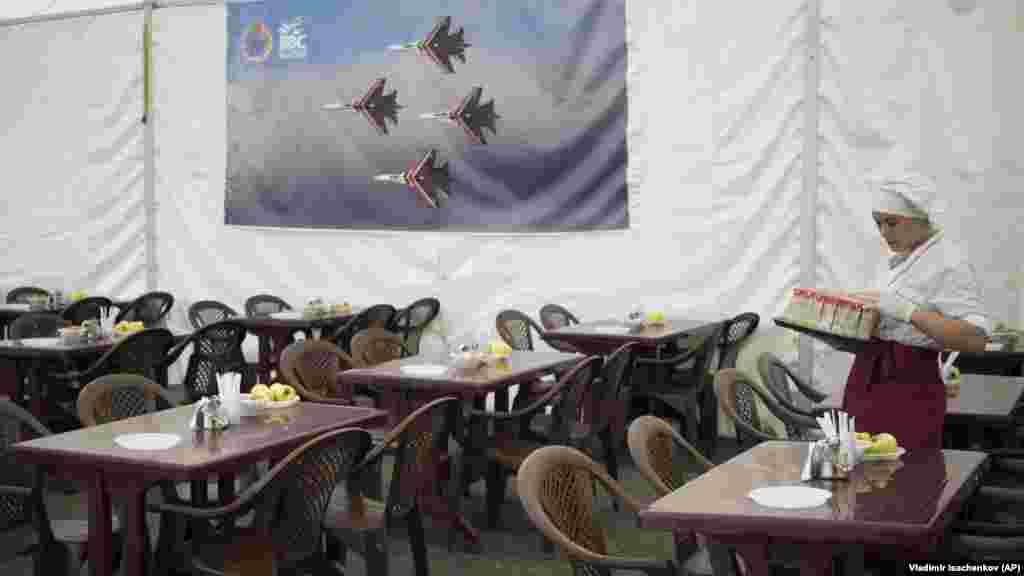 Руска сервитьорка подрежда маси в кафене в базата Хмеймим през октомври 2015 г. Робърт Е. Хамилтън, ръководител на изследователския отдел за Евразия в американския Институт за външнополитически изследвания, казва пред Радио Свободна Европа, че новите управляващи в Сирия може и да не са склонни да толерират базите, от които Кремъл "години наред е извършвал нападения срещу ХТС, други опозиционни групировки и сирийски цивилни&ldquo;.