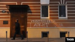 Мъж преминава покрай входа на правозащитния център "Мемориал" в Москва. На стената на сградата пише: "Чуждестранен агент" и "Обичам САЩ". 21 ноември 2012 г.