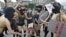 Members of the activist group FEMEN, dressed in scanty "riot police" outfits, pretend to beat up a reporter during a rally against censorship and repression in the Ukrainian media.