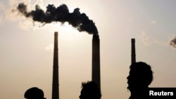 Люди проходят мимо электростанции в Шанхае, 5 декабря 2009 года.  