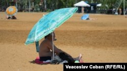 Un bărbat pe plaja urbană din Parcul La Izvor, Chișinău. Specialiștii recomandă să evităm expunerea prelungită la soare și să folosim creme cu protecție solară pentru a ne proteja.